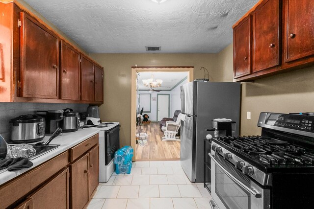 2105 Russell St, Houston, TX 77026 - kitchen featuring visible vents, stainless steel appliances, light countertops, a textured ceiling, and a chandelier