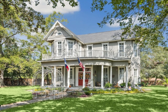 725 Columbus Rd, Sealy, TX 77474 - victorian house with a front yard, a porch, fence, and roof with shingles