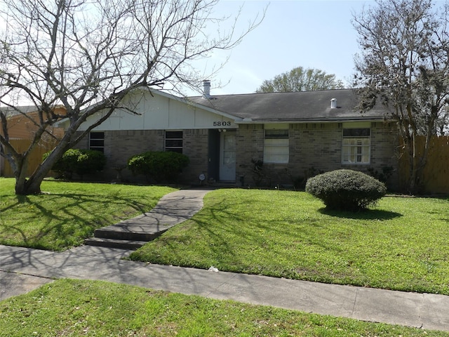 ranch-style house with a front yard and brick siding