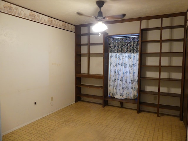 unfurnished room featuring brick floor, baseboards, and ceiling fan