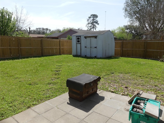 view of yard with a storage unit, an outdoor structure, a fenced backyard, and a patio area