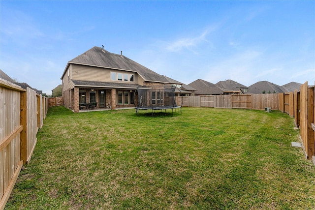 17131 Lumberton Dr, Cypress, TX 77433 - back of house featuring a trampoline, brick siding, and a patio