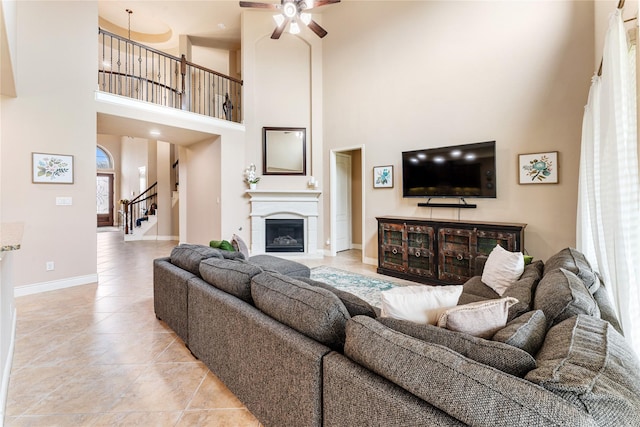 17131 Lumberton Dr, Cypress, TX 77433 - living area featuring a high ceiling, light tile patterned flooring, stairs, ceiling fan, and baseboards
