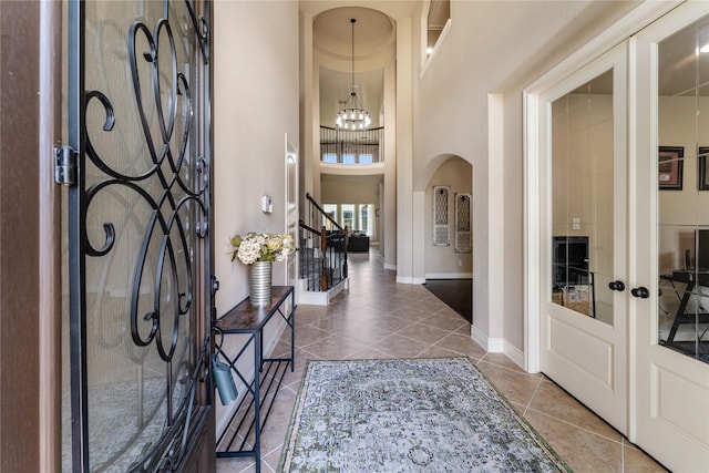 17131 Lumberton Dr, Cypress, TX 77433 - entrance foyer featuring a chandelier, arched walkways, stairs, tile patterned floors, and french doors