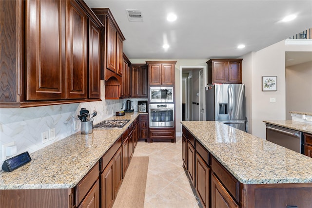 17131 Lumberton Dr, Cypress, TX 77433 - kitchen featuring stainless steel appliances, a center island, backsplash, light stone countertops, and recessed lighting