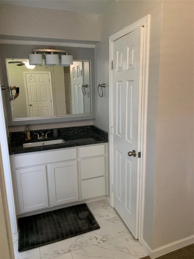 bathroom featuring baseboards, marble finish floor, and vanity