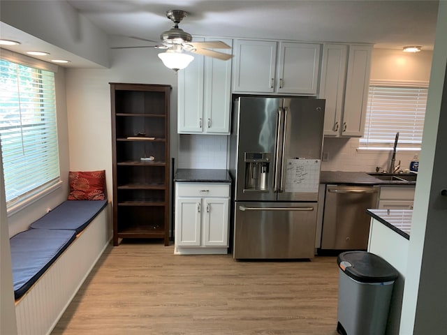 kitchen with dark countertops, light wood finished floors, stainless steel appliances, and ceiling fan