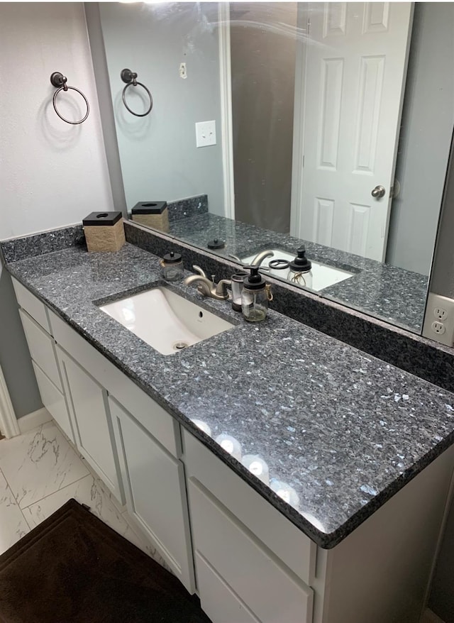 bathroom featuring baseboards, marble finish floor, and vanity