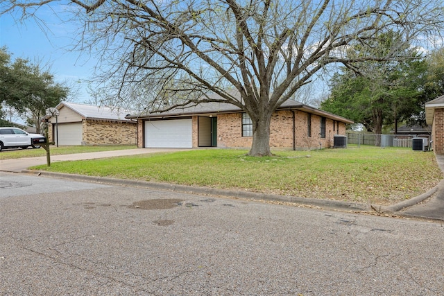 view of front of home with a front yard, cooling unit, fence, a garage, and brick siding