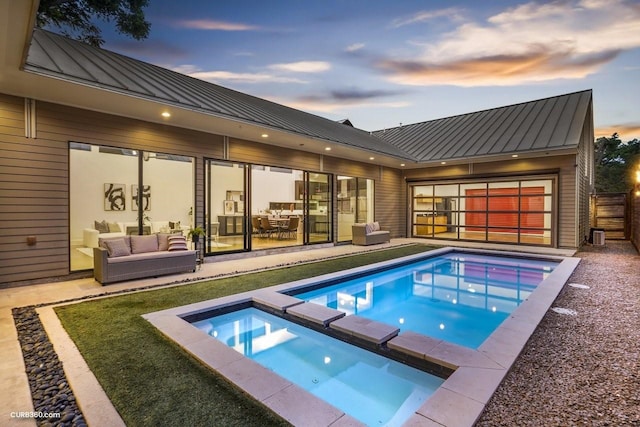 1035 Rutland St, Houston, TX 77008 - pool at dusk featuring an outdoor living space, a pool with connected hot tub, and a patio