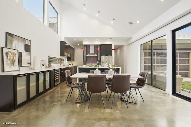 1035 Rutland St, Houston, TX 77008 - dining room with finished concrete flooring, wine cooler, high vaulted ceiling, plenty of natural light, and recessed lighting