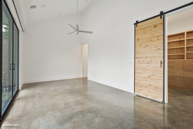 1035 Rutland St, Houston, TX 77008 - unfurnished bedroom with finished concrete floors, a barn door, baseboards, and high vaulted ceiling