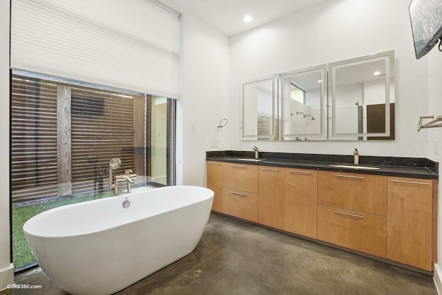 1035 Rutland St, Houston, TX 77008 - bathroom featuring concrete floors, double vanity, a freestanding bath, and recessed lighting
