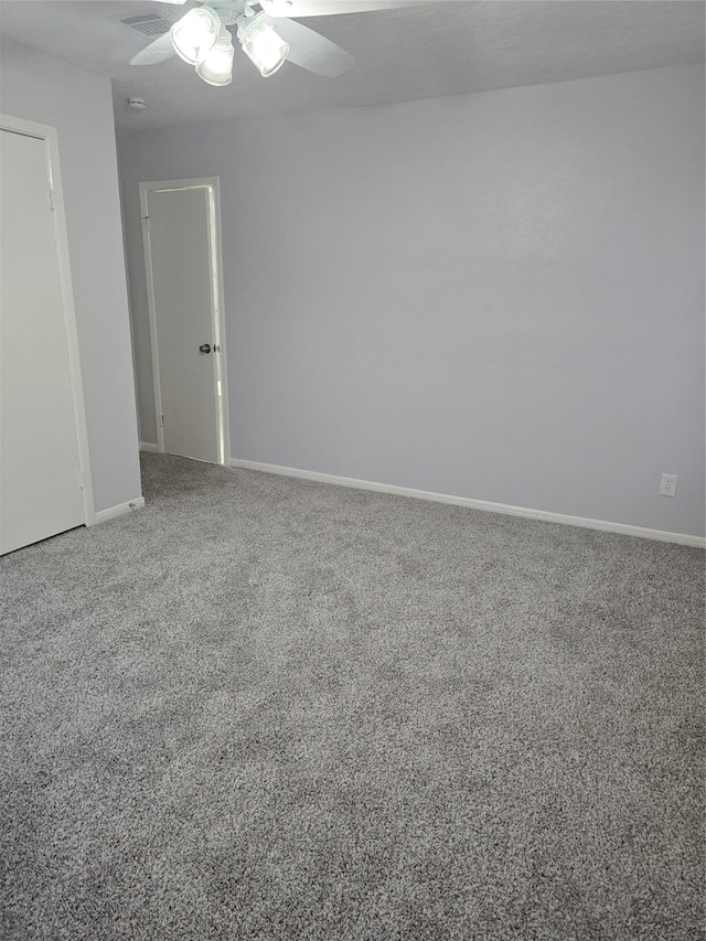 carpeted empty room with ceiling fan and baseboards