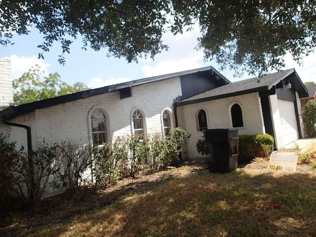view of side of home with a chimney and an attached garage