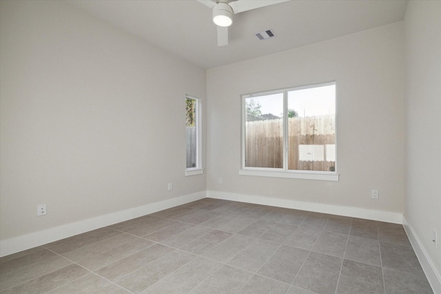 tiled spare room with a ceiling fan, baseboards, and visible vents