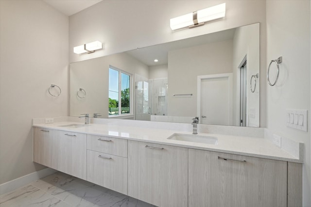 full bathroom featuring double vanity, marble finish floor, a stall shower, and a sink