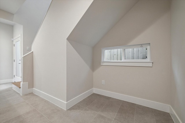 bonus room with tile patterned flooring, lofted ceiling, and baseboards