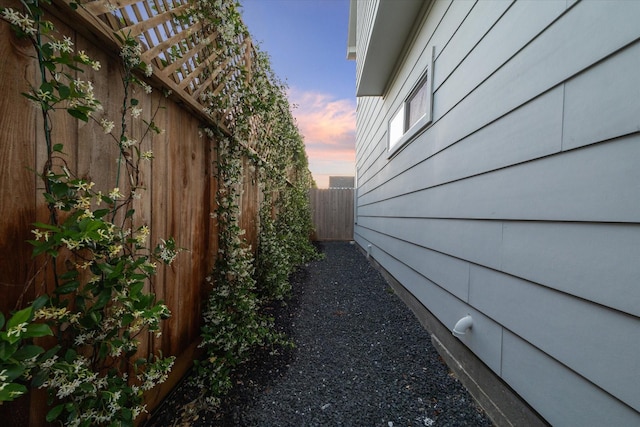 property exterior at dusk featuring fence