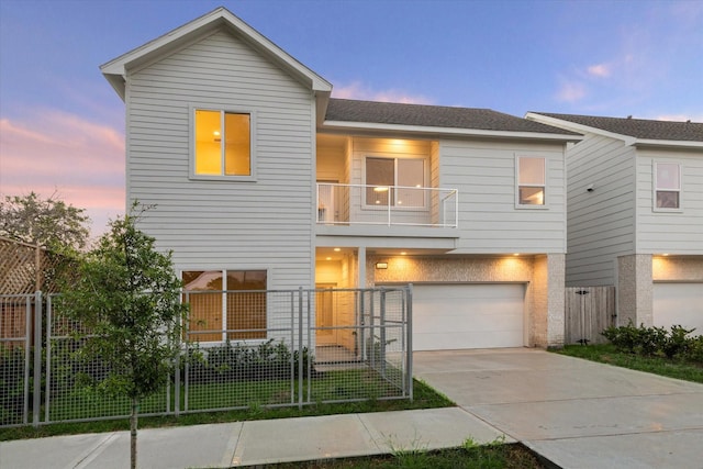 multi unit property with fence, roof with shingles, concrete driveway, a garage, and a balcony