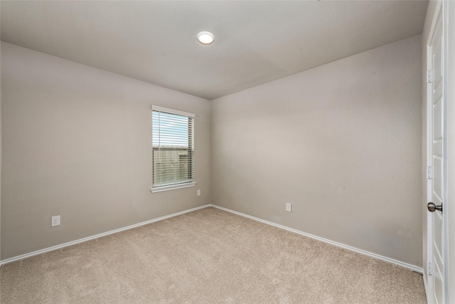 carpeted empty room with baseboards