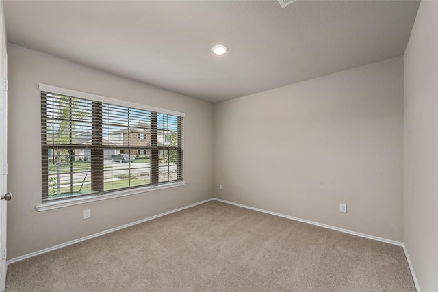 carpeted empty room featuring baseboards