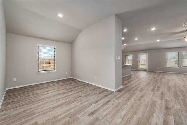 unfurnished room with baseboards, light wood-style flooring, a ceiling fan, and lofted ceiling