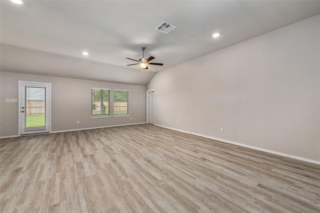 spare room with a ceiling fan, visible vents, baseboards, lofted ceiling, and light wood-style flooring