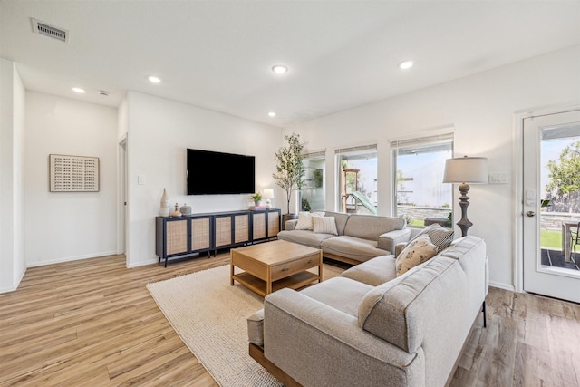 living room with recessed lighting, visible vents, baseboards, and light wood-style floors