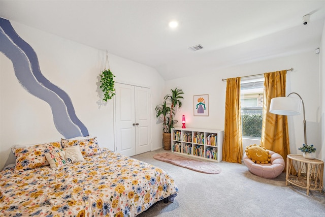 carpeted bedroom featuring a closet, visible vents, and vaulted ceiling