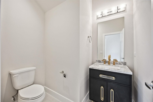 half bath with vanity, toilet, and baseboards