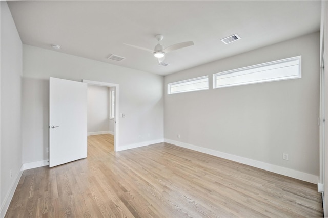 empty room featuring visible vents, light wood-style flooring, baseboards, and ceiling fan