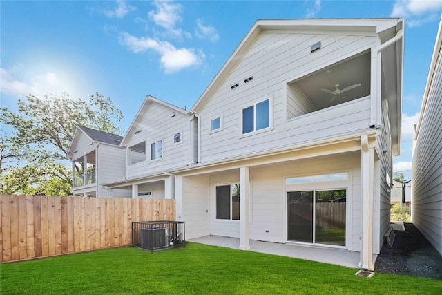 rear view of property with a yard, fence, a patio area, and central AC unit