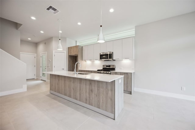 kitchen featuring a sink, stainless steel appliances, modern cabinets, and visible vents