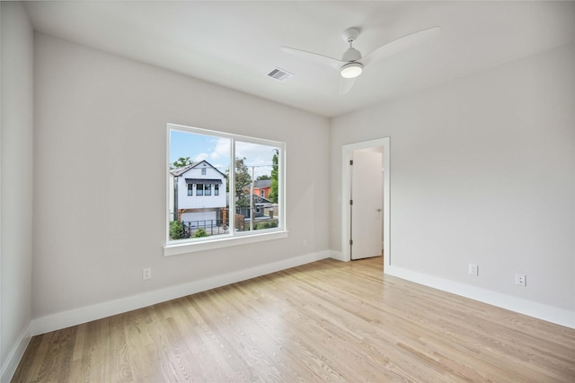 unfurnished room featuring ceiling fan, baseboards, visible vents, and wood finished floors