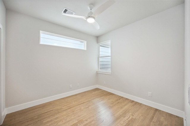 unfurnished room featuring ceiling fan, baseboards, visible vents, and light wood-style floors