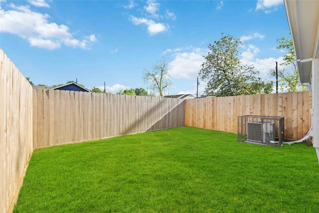 view of yard with central AC unit and a fenced backyard