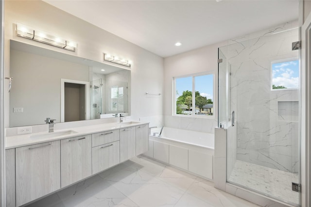 bathroom featuring a marble finish shower, plenty of natural light, and a sink