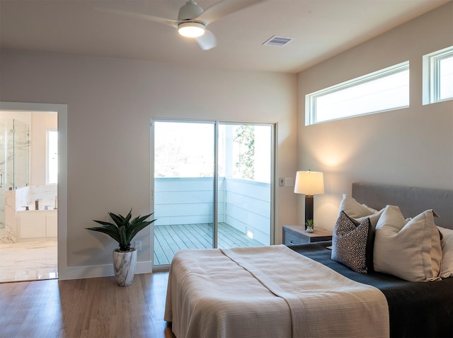 bedroom featuring ensuite bathroom, wood finished floors, baseboards, visible vents, and access to outside