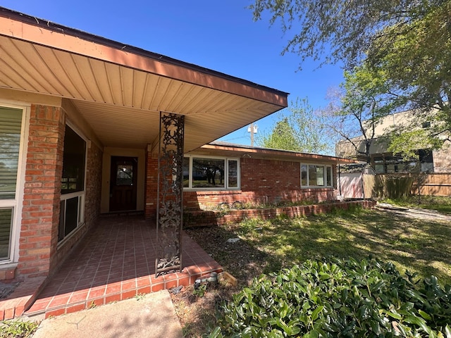 view of exterior entry featuring brick siding