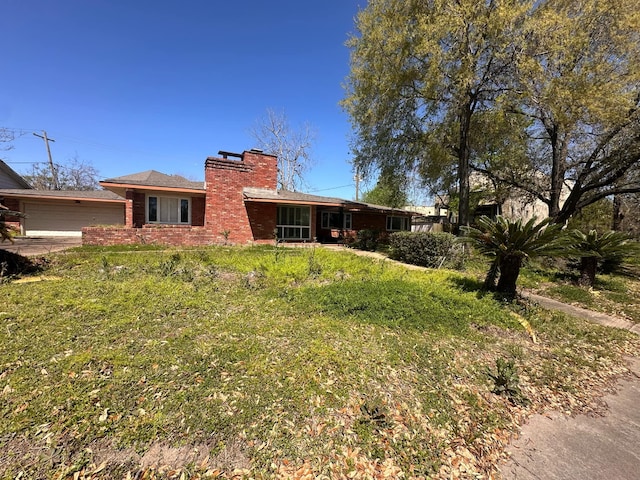 view of front facade featuring a garage, brick siding, and a chimney
