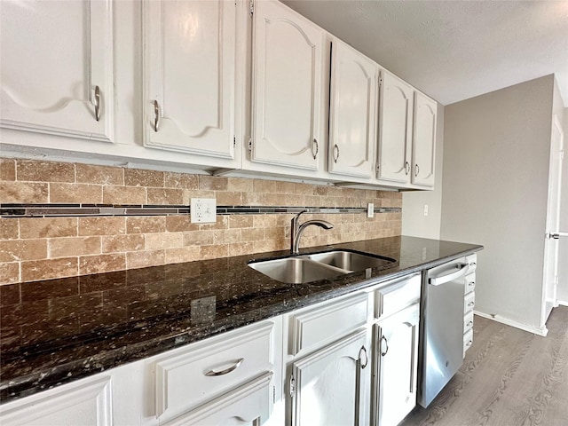 kitchen with a sink, light wood-style floors, dishwasher, and white cabinetry