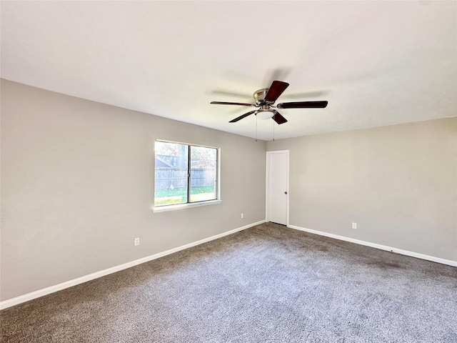 unfurnished room with dark colored carpet, baseboards, and a ceiling fan