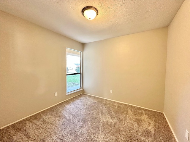 empty room featuring baseboards, a textured ceiling, and carpet flooring