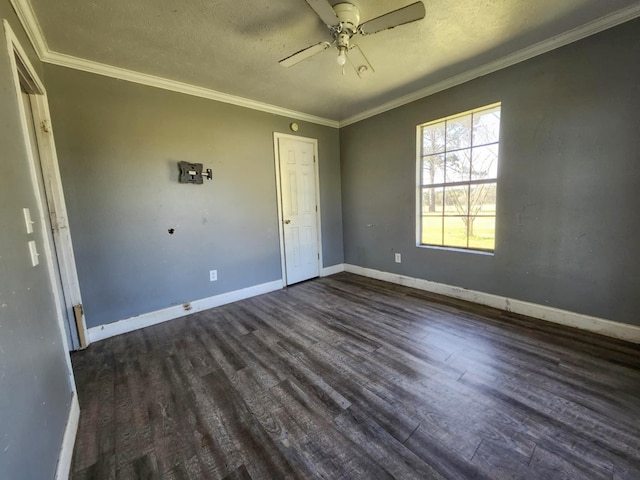 spare room featuring ornamental molding, ceiling fan, baseboards, and dark wood-style floors