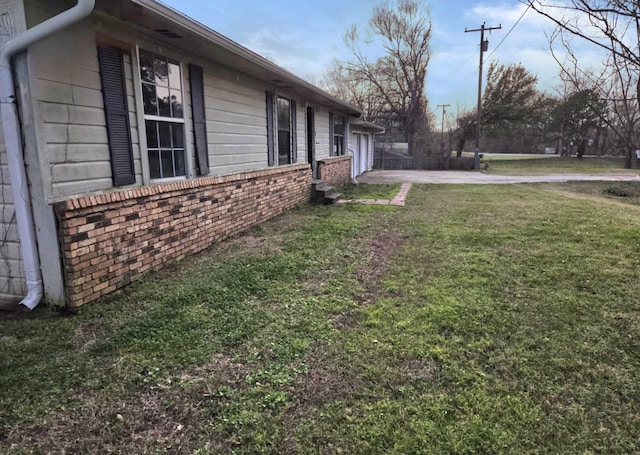 view of yard featuring a garage and driveway