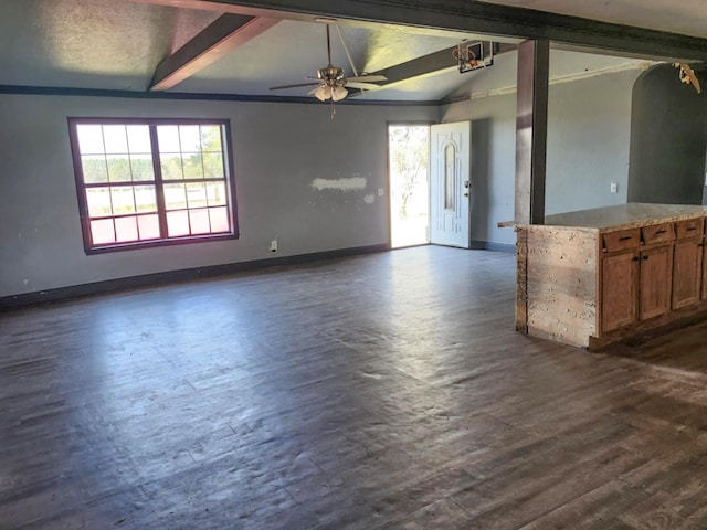 unfurnished living room featuring dark wood-type flooring, baseboards, plenty of natural light, and lofted ceiling with beams