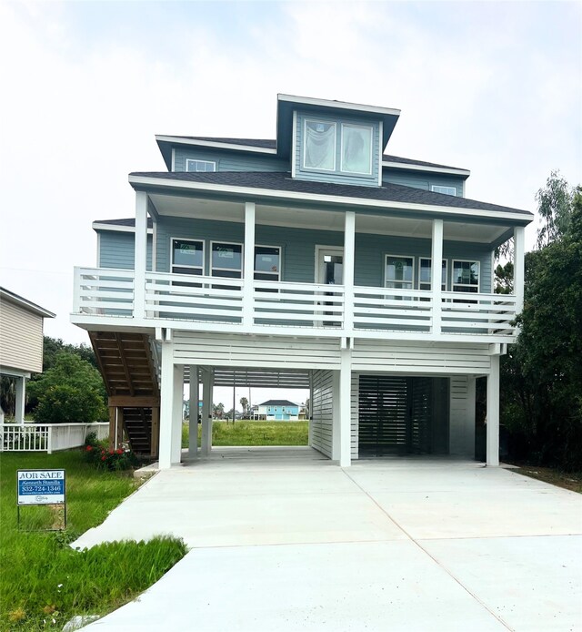 3903 Pirates Beach Cir, Galveston, TX 77554 - coastal home featuring a carport, concrete driveway, a porch, and stairway