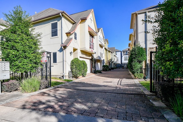 view of road featuring decorative driveway and a residential view