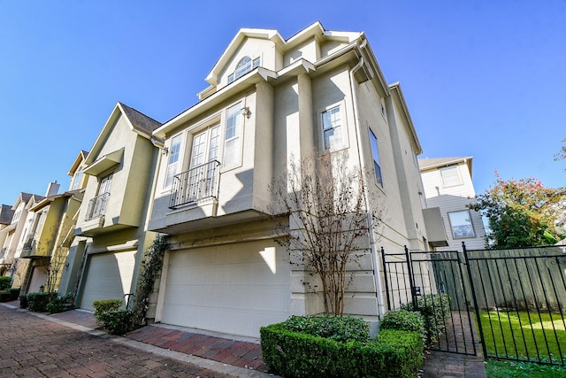 view of side of home with fence, a garage, and stucco siding